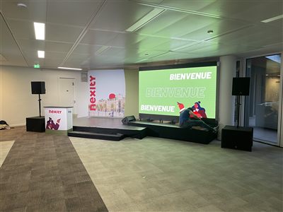 Écran LED affichant un message de bienvenue sur la scène d'un séminaire d'entreprise