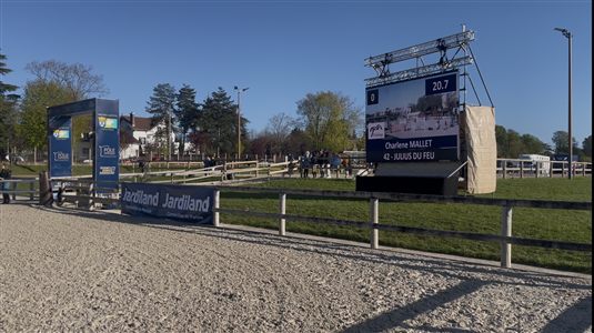 Écran LED sur structure affichant les scores en direct d'un concours hippique